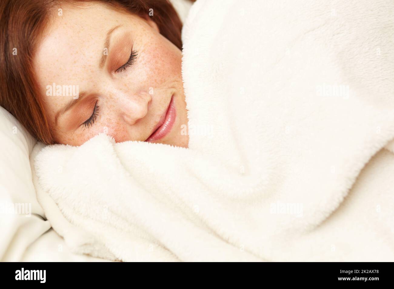 Angenehme Träume. Eine schöne junge Frau schläft glücklich in ihrem Bett. Stockfoto