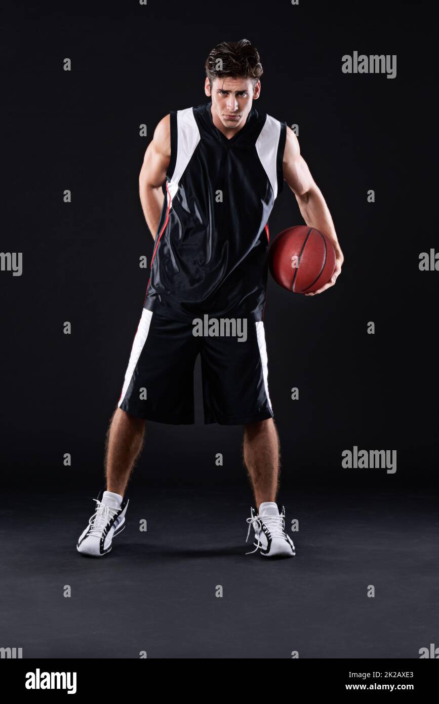 Verlieren ist keine Option. In voller Länge Porträt eines männlichen Basketballspielers in Aktion vor einem schwarzen Hintergrund. Stockfoto