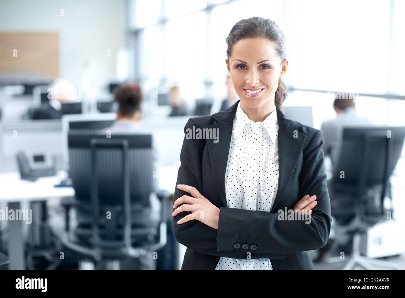 Selbstbewusst in ihrer beruflichen Entscheidung. Attraktive junge Geschäftsfrau, die selbstbewusst im Büro steht - Porträt. Stockfoto
