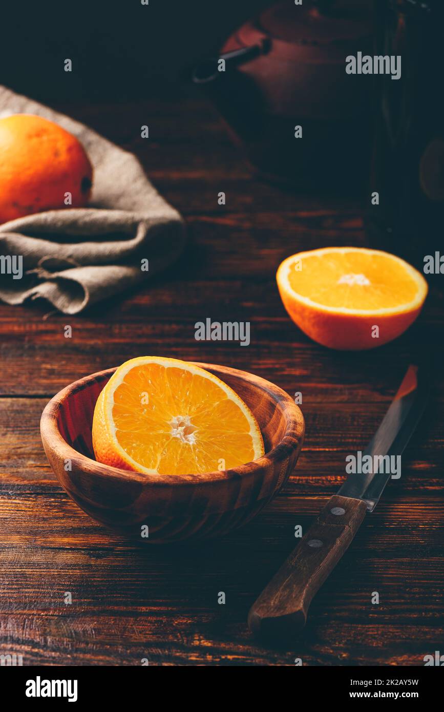 Eine Hälfte Orange in einer Holzschüssel Stockfoto