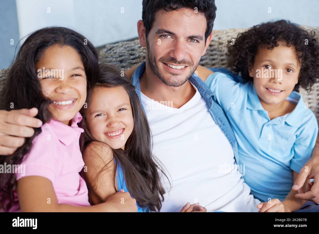 Wir teilen die stärksten Familienanleihen. Porträt einer glücklichen alleinerziehenden Familie, die auf einem Sofa sitzt und die Kamera anlächelt. Stockfoto