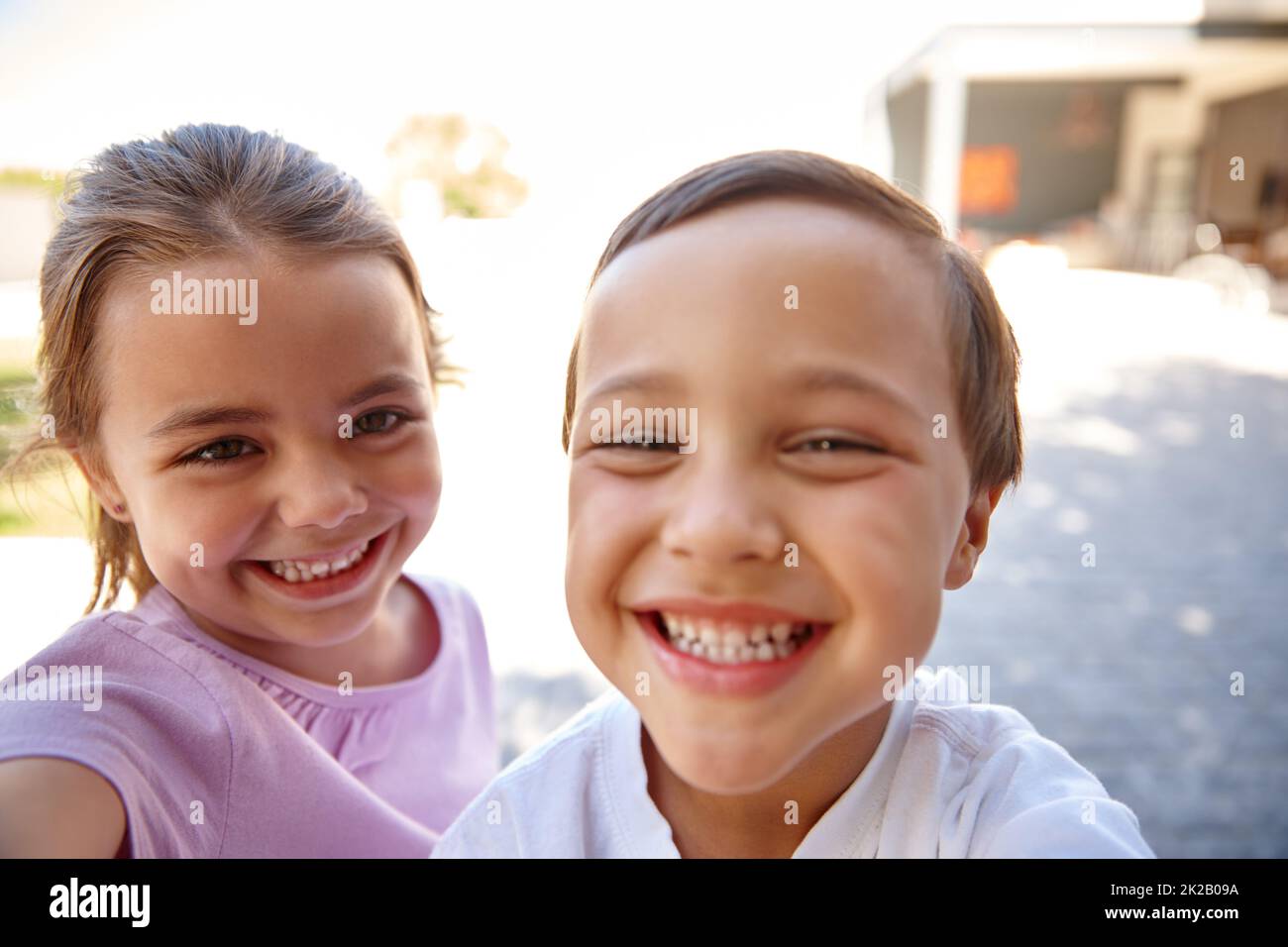 Sie waren so aufgeregt. Zwei niedliche kleine Kinder lächeln und lachen zusammen. Stockfoto