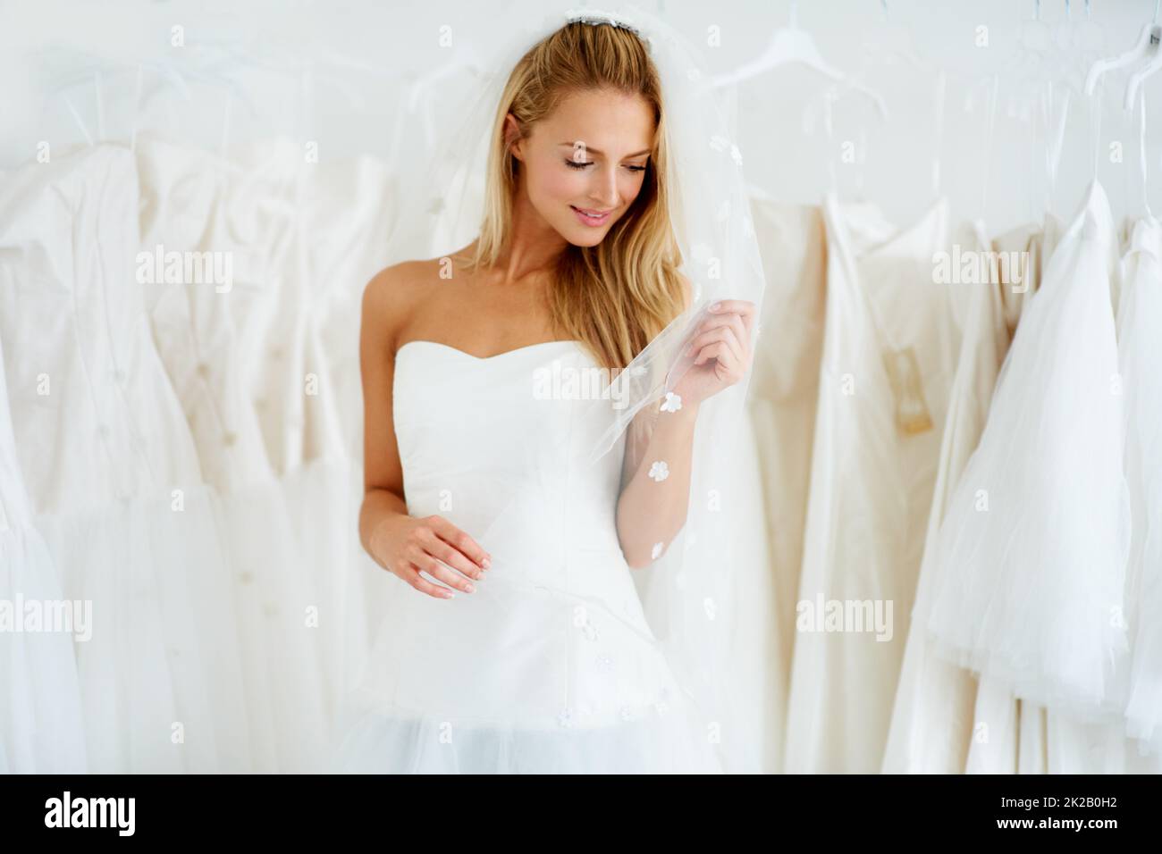 Shes gehen, um eine schöne Braut zu machen. Eine junge Braut, die ihr Hochzeitskleid anprobiert - Copyspace. Stockfoto