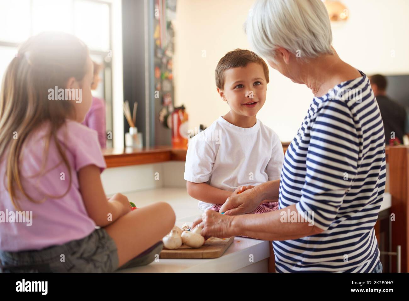 Gesunde Ernährung beginnt zu Hause. Kurzer Schuss einer Großmutter, die mit ihren Enkeln in einer Küche Gemüse wäscht. Stockfoto