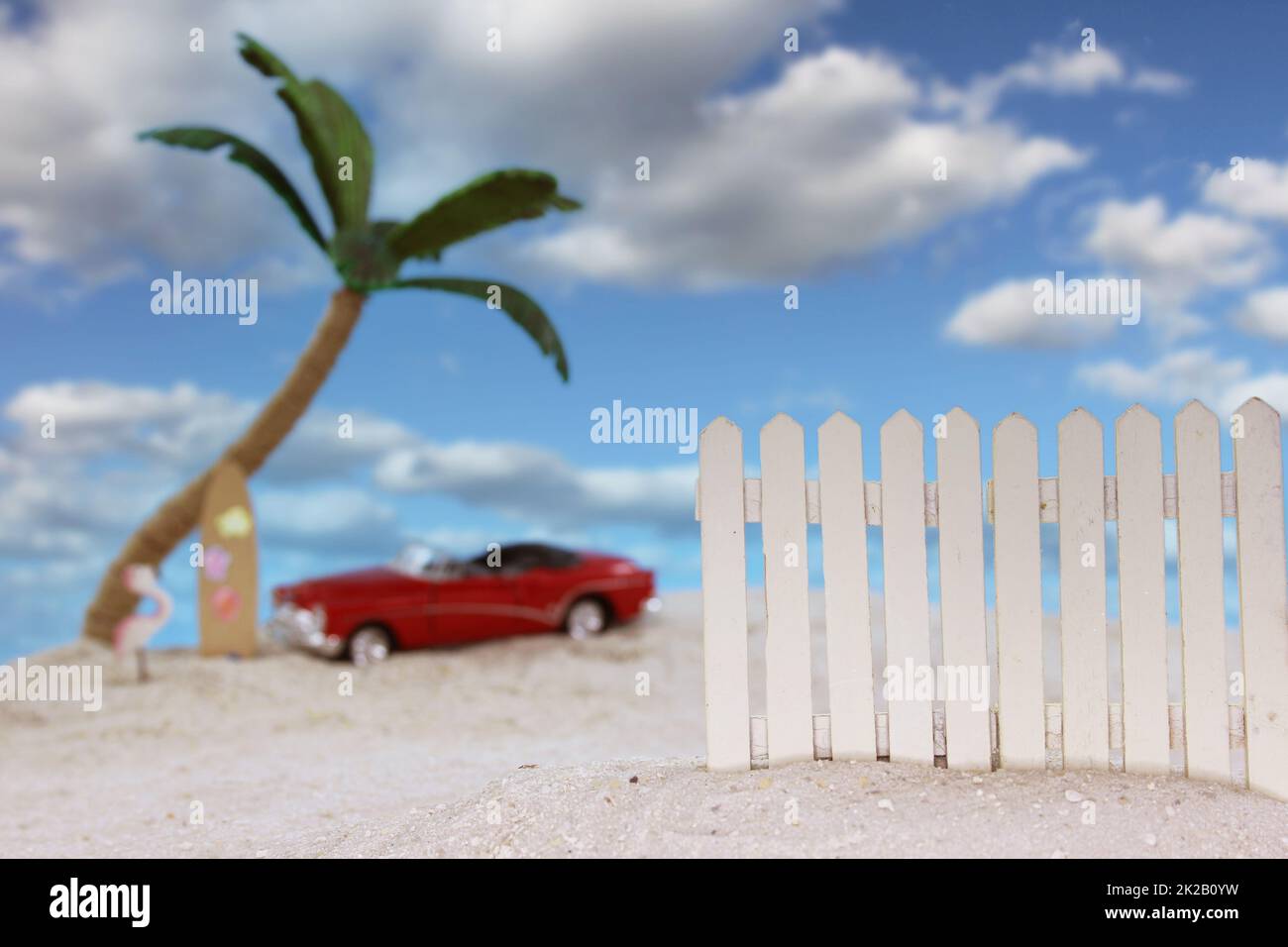 Zaun am tropischen Strand mit Vintage Hot Rod im Hintergrund Stockfoto