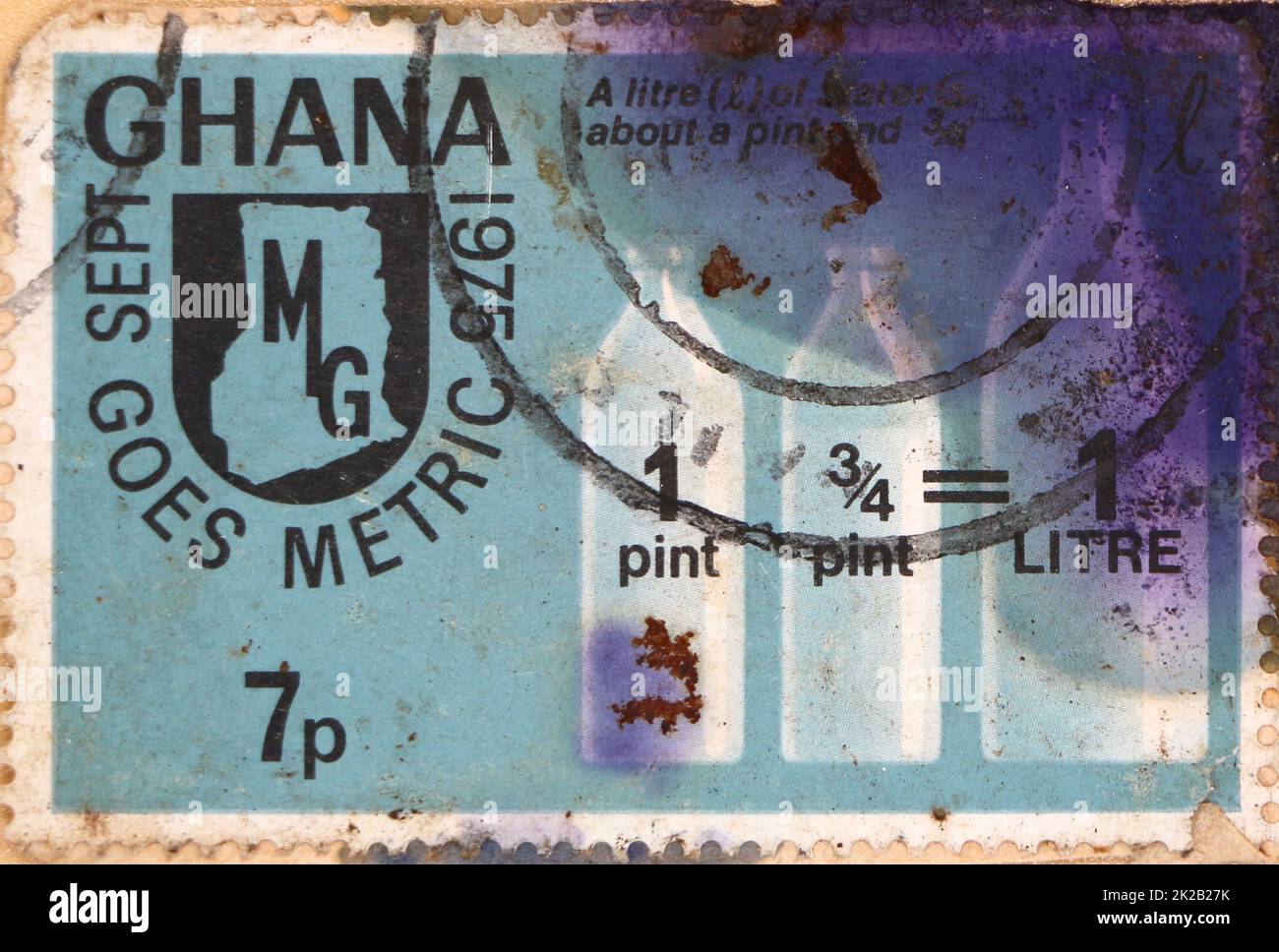 Foto einer mit Tinte befleckten Briefmarke aus Ghana mit einer Erklärung für Ghana, die metrisch 1 3/4 Pints = 1 Liter 1975 läuft Stockfoto