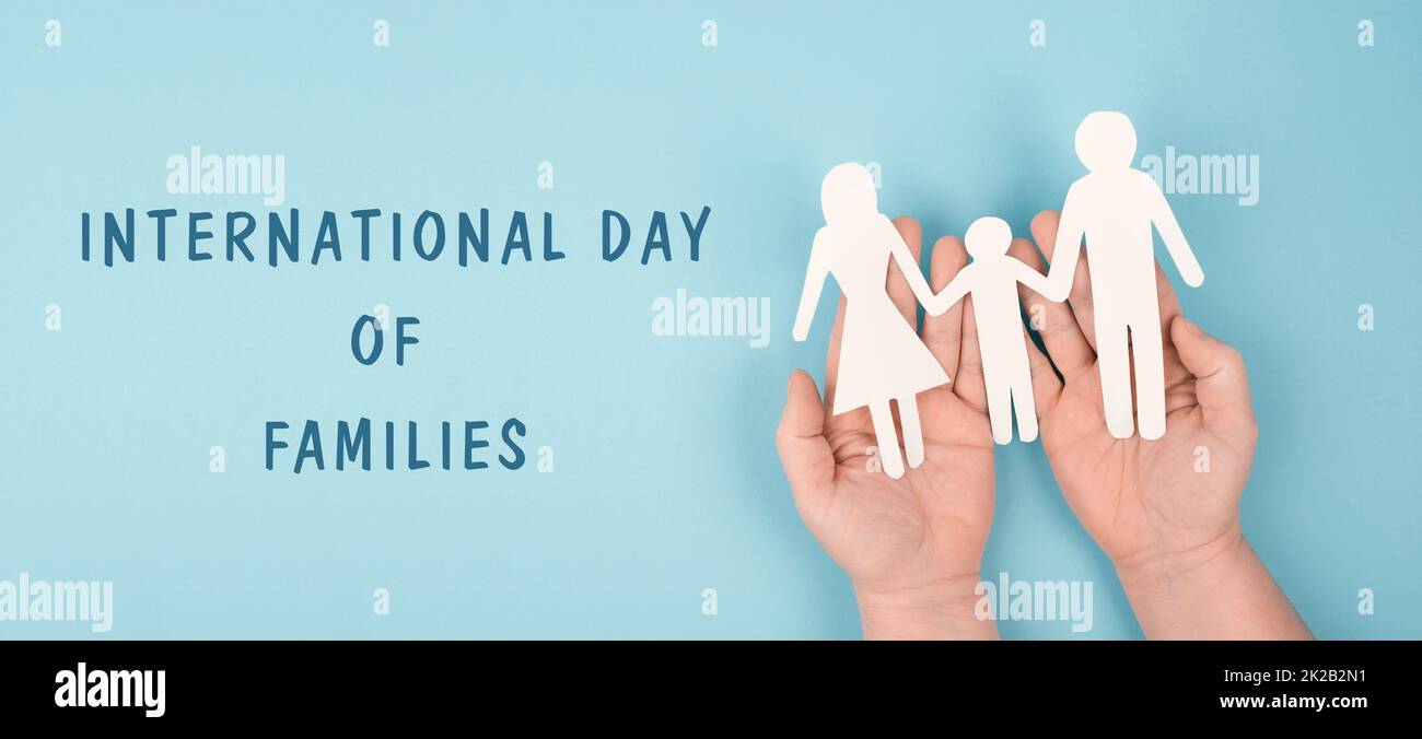 Internationaler Tag der Familien, Eltern mit einem Kind, das die Hände hält, Papier ausgeschnitten, blauer Hintergrund, Beziehung Stockfoto Internationaler Tag der Familien, Eltern mit einem Kind, das die Hände hält, Papier ausgeschnitten, blauer Hintergrund, Beziehung Stockfoto