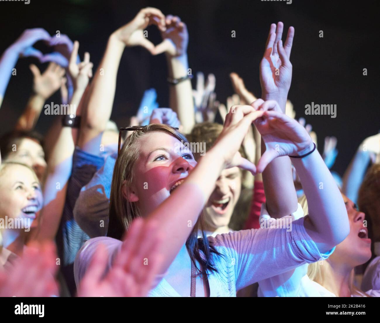 Wir lieben dich. Fans, die ein Musikkonzert genießen, anbeten. Stockfoto