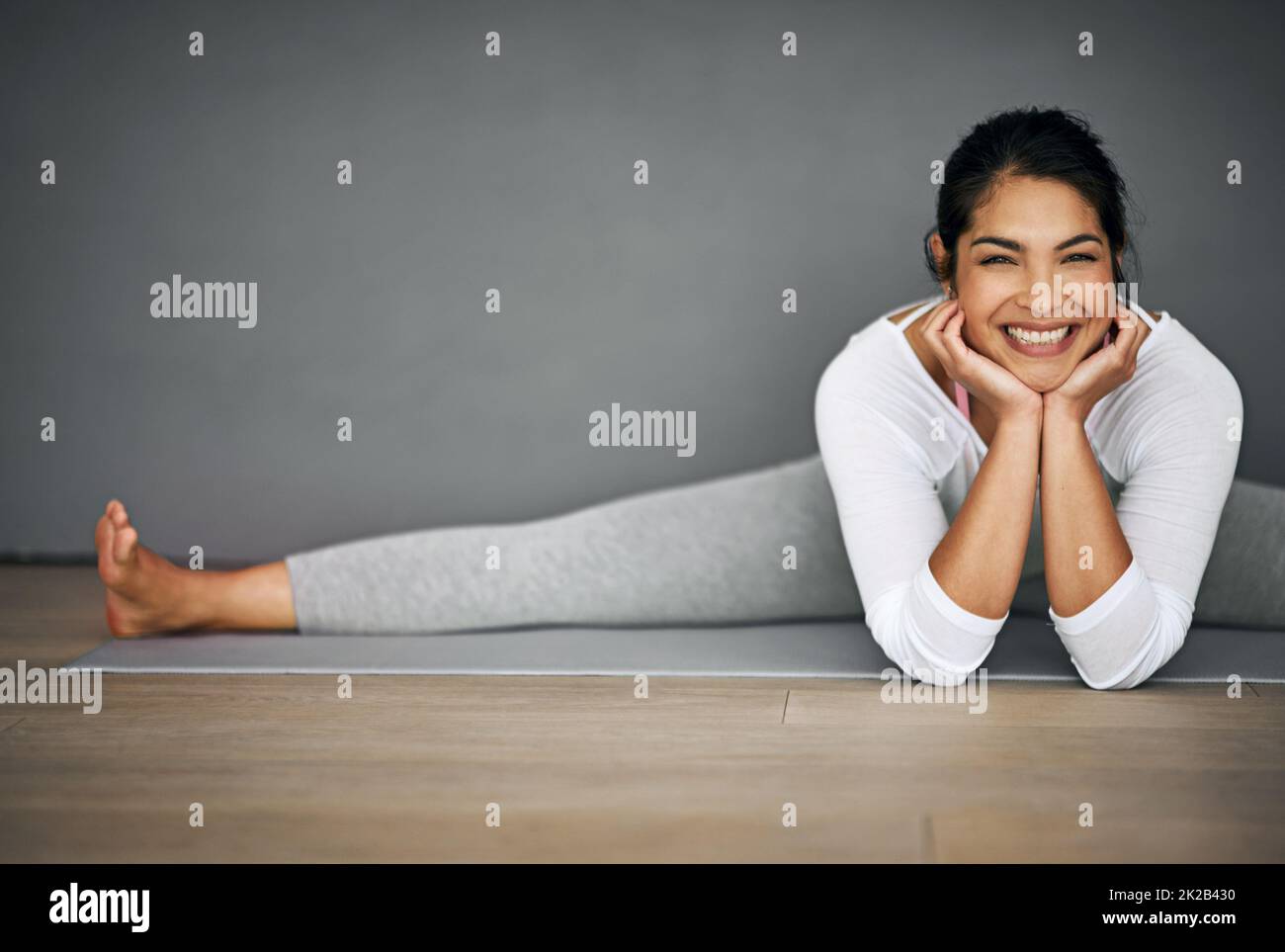 Yoga setzte mir dieses Lächeln ins Gesicht. Porträt einer attraktiven jungen Frau, die die Splits in ihrer Yoga-Routine macht. Stockfoto
