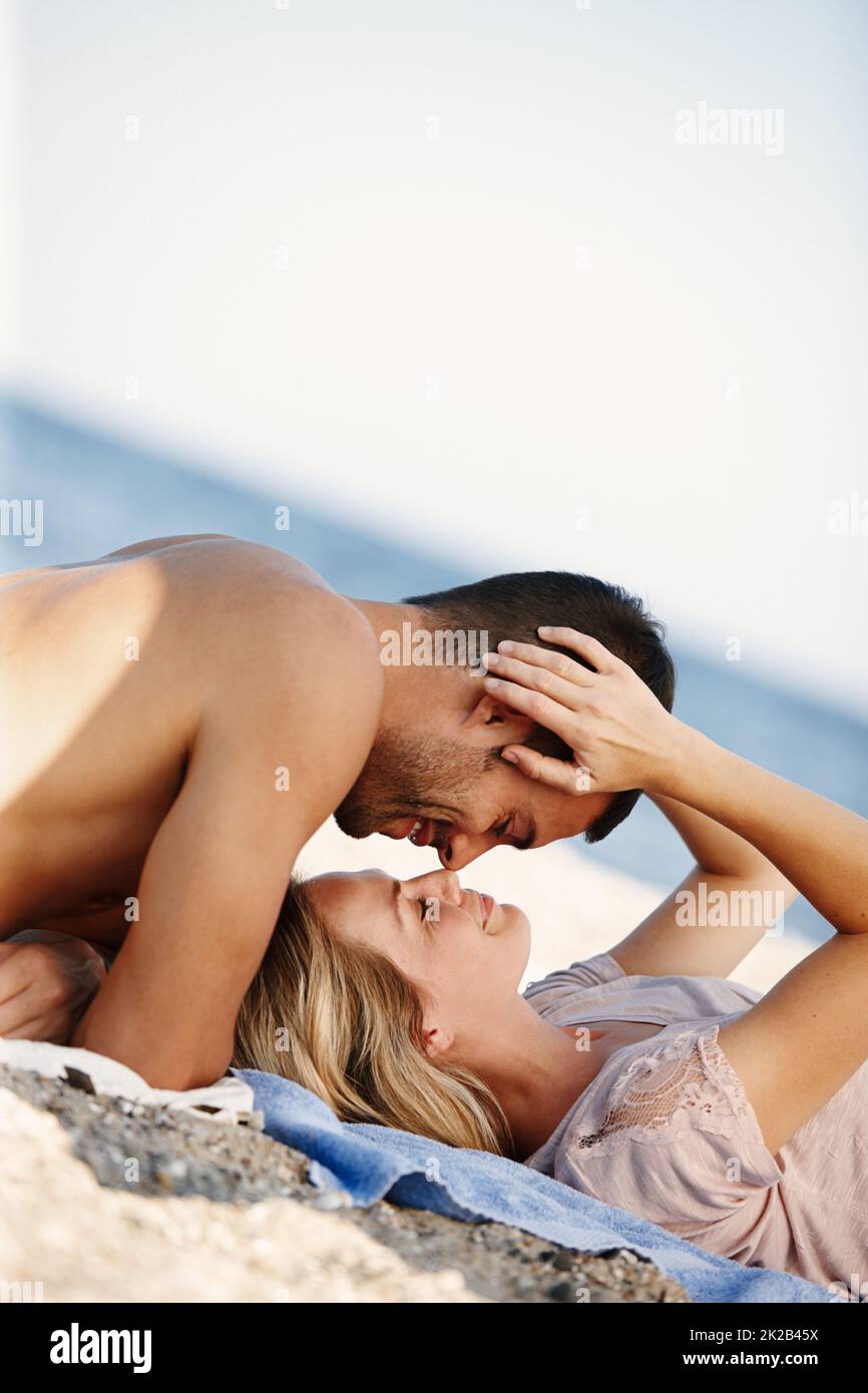 Die perfekte Strandromantik. Aufnahme eines liebevollen jungen Paares, das einen romantischen Tag am Strand genießt. Stockfoto