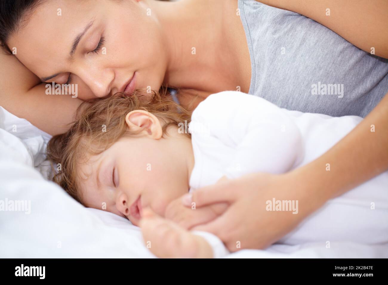 Sie ist genauso müde wie ihre Tochter. Eine Mutter und Tochter schlafen auf dem Bett. Stockfoto