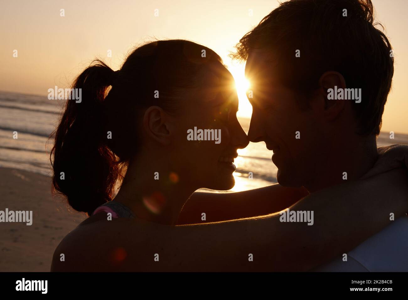 Wahre Liebe bei Sonnenuntergang. Silhouette eines Paares, das bei Sonnenuntergang am Strand romantisch ist. Stockfoto