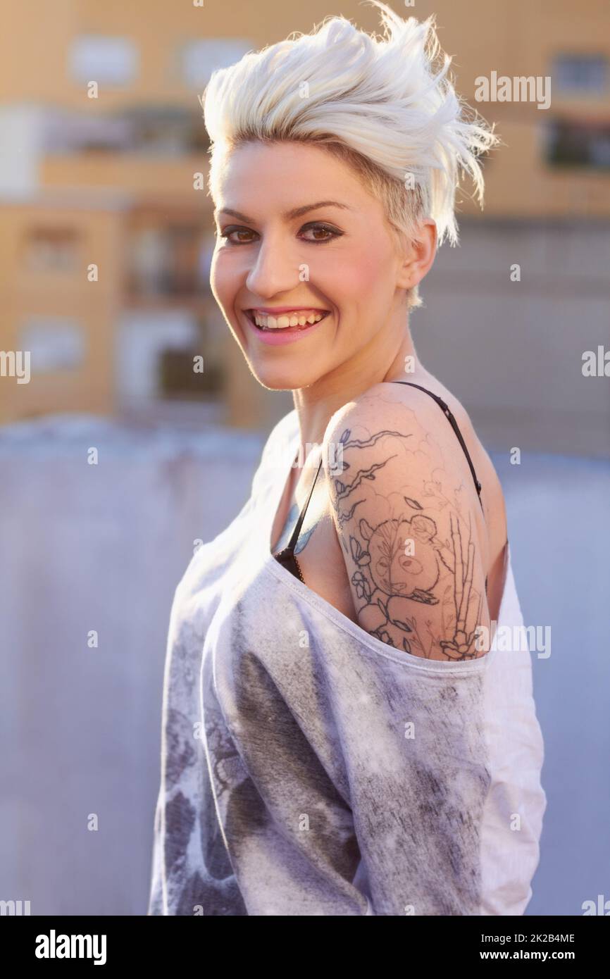 Halte meinen Stil fest. Aufnahme einer jungen Frau mit Tattoos. Stockfoto
