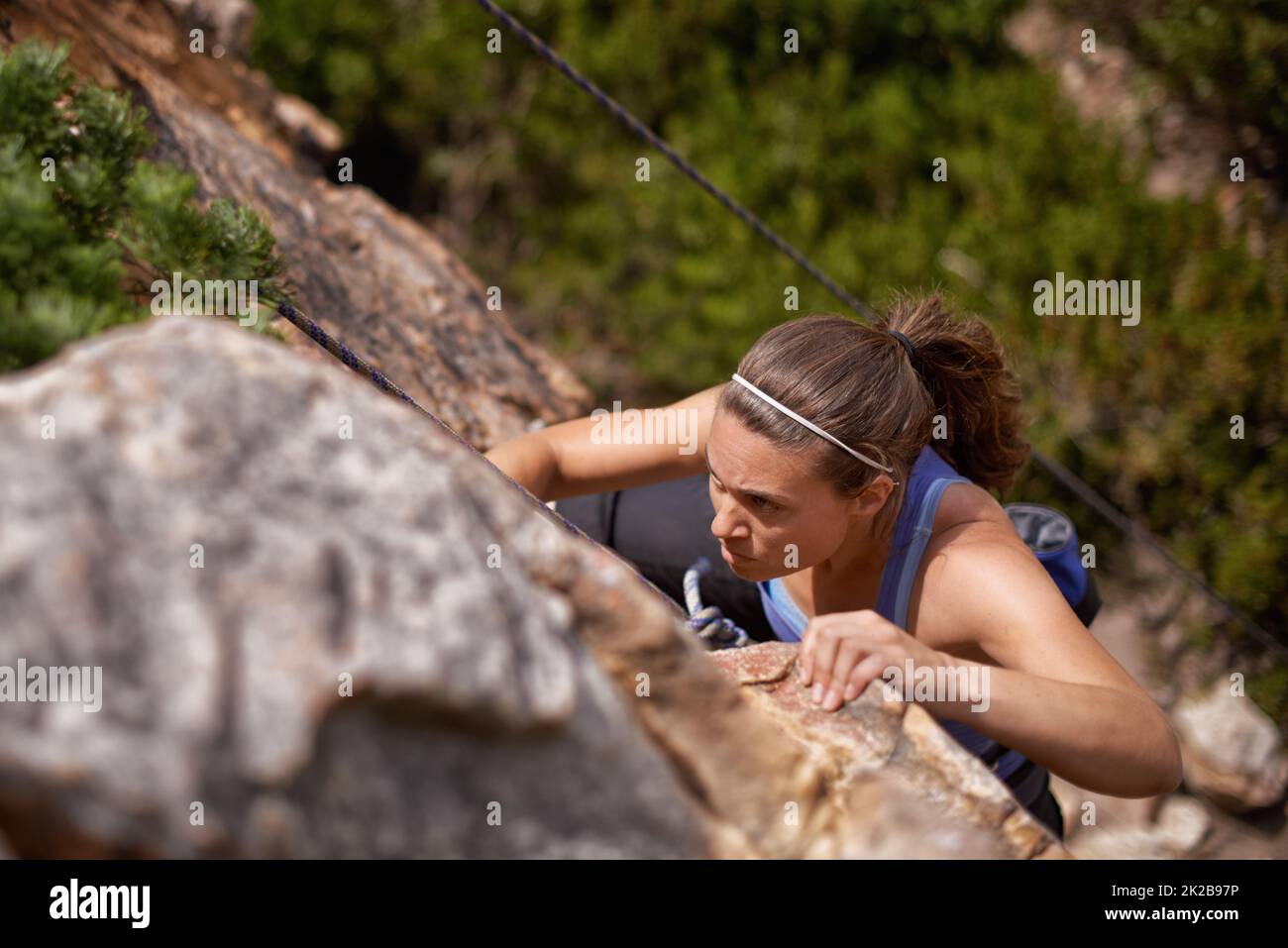 Shes entschlossen, die Spitze zu erreichen. Aufnahme einer jungen Frau, die einen Bergfelsen klettert. Stockfoto