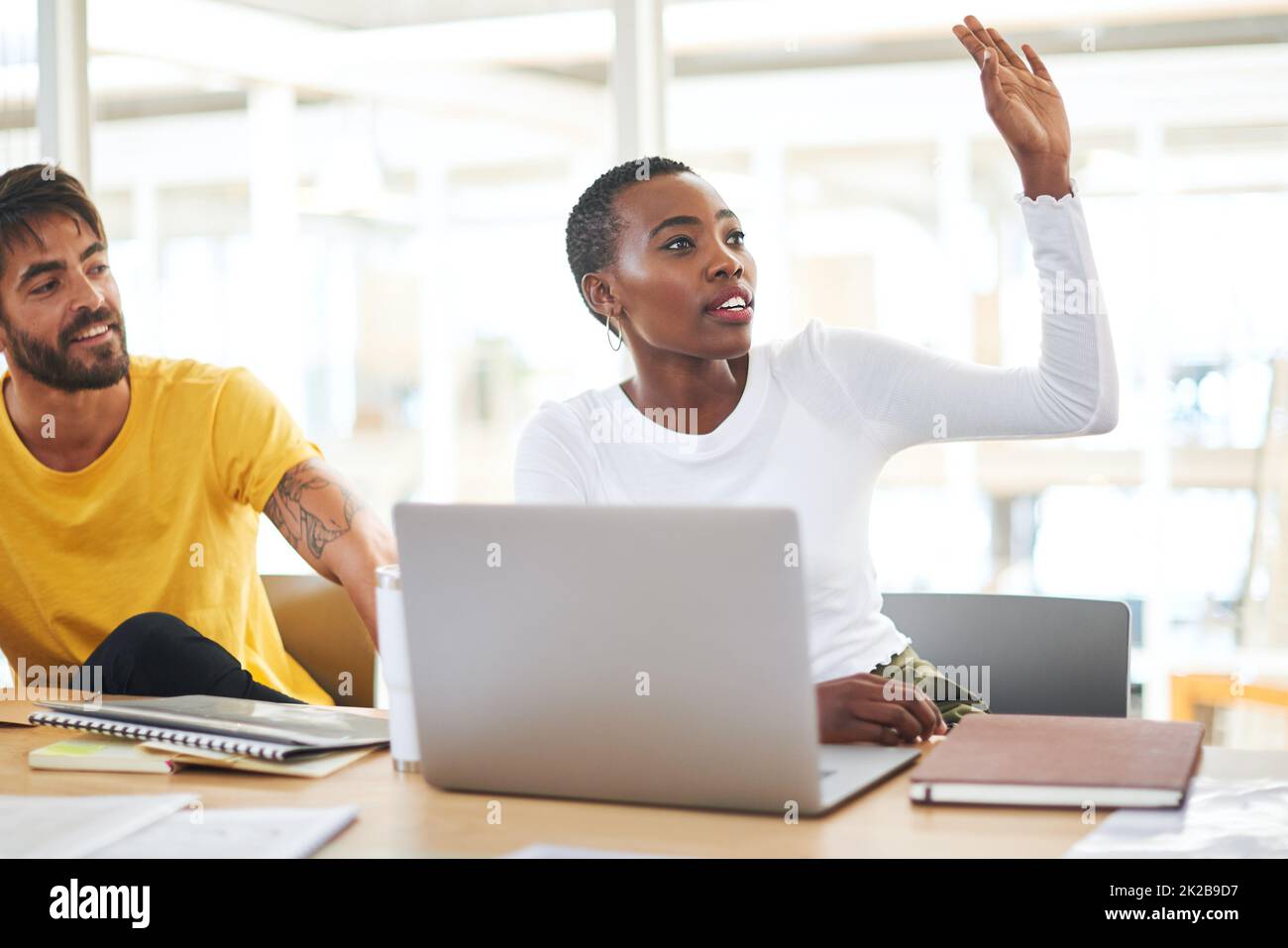 Stellen Sie mehr Fragen, gewinnen Sie mehr Klarheit. Aufnahme einer jungen Geschäftsfrau, die während eines Meetings in einem modernen Büro ihre Hand hob, um eine Frage zu stellen. Stockfoto