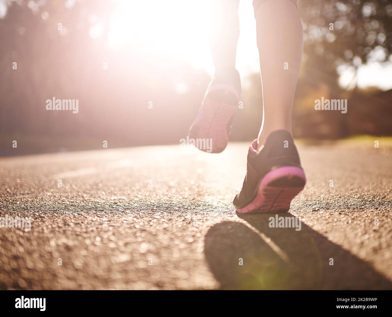 Trainieren Sie, wie es keine Ziellinie gibt. Kurze Aufnahme einer Frau, die sich für einen Lauf die Beine ausstreckt. Stockfoto