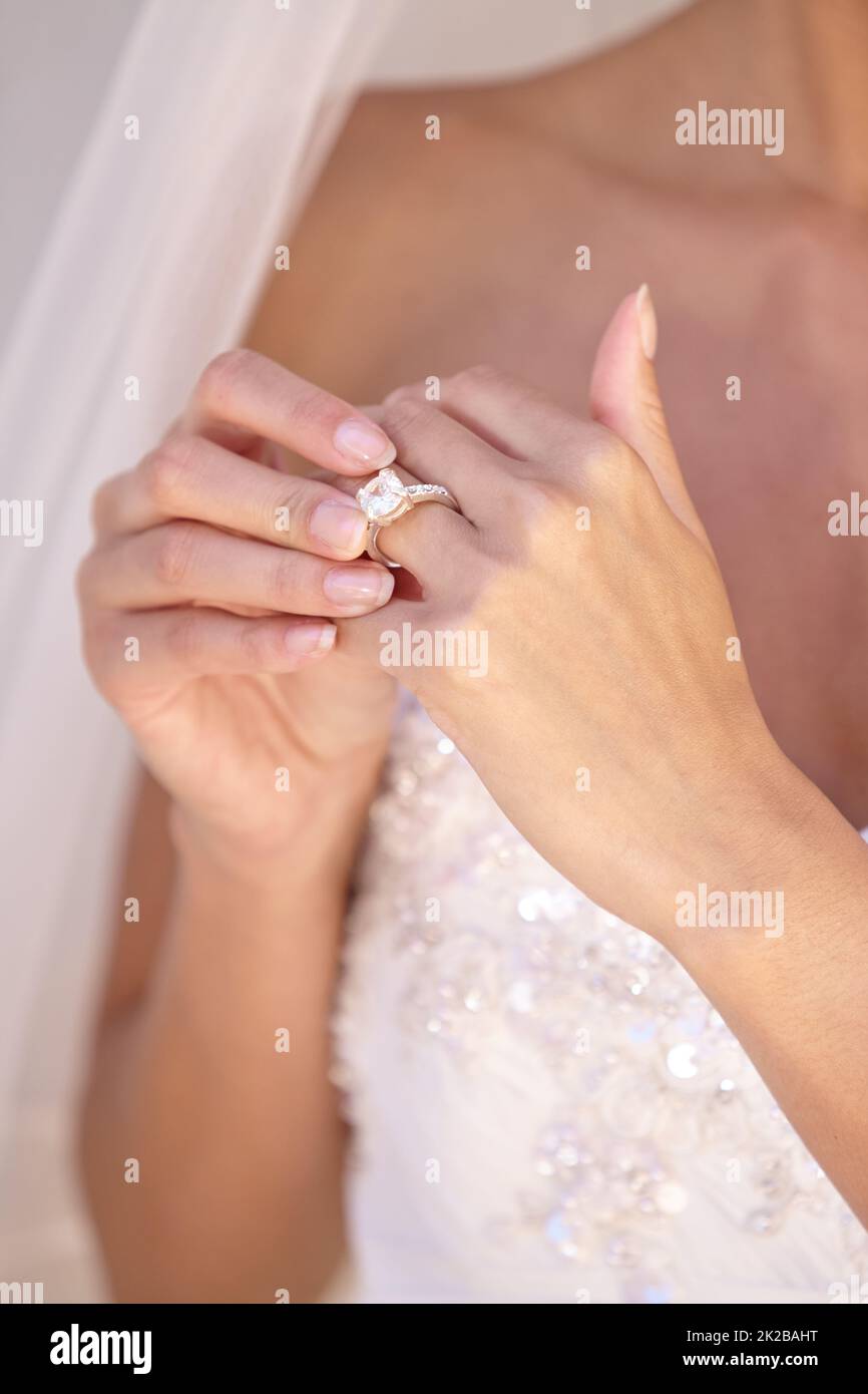 Es ist perfekt. Schöne Braut in ihrem Hochzeitskleid berühren ihren Ehering. Stockfoto