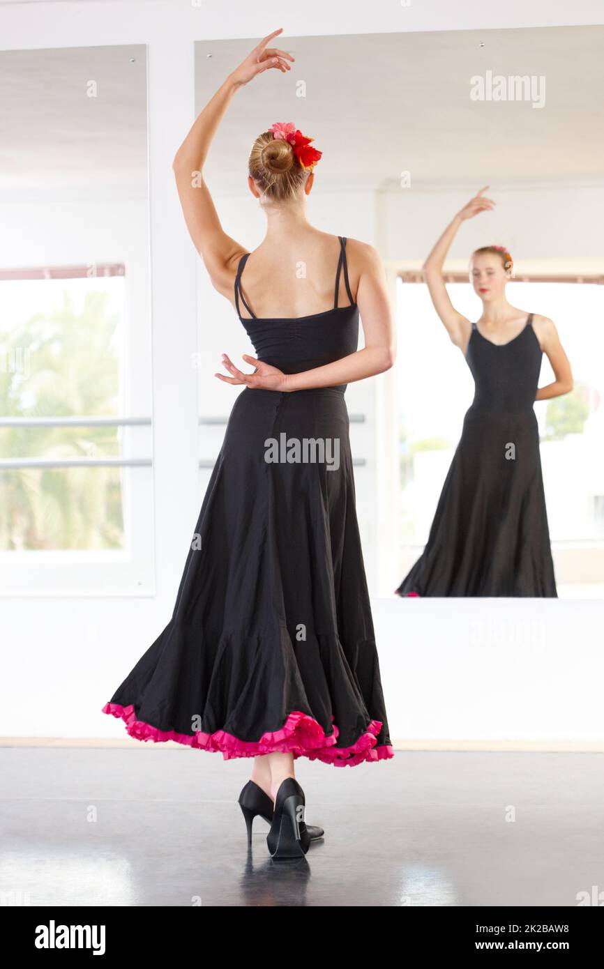 Sorgfältig kontrollierte Leidenschaft. Junge Tänzerin, die Flamenco in einem Tanzstudio aufführt. Stockfoto