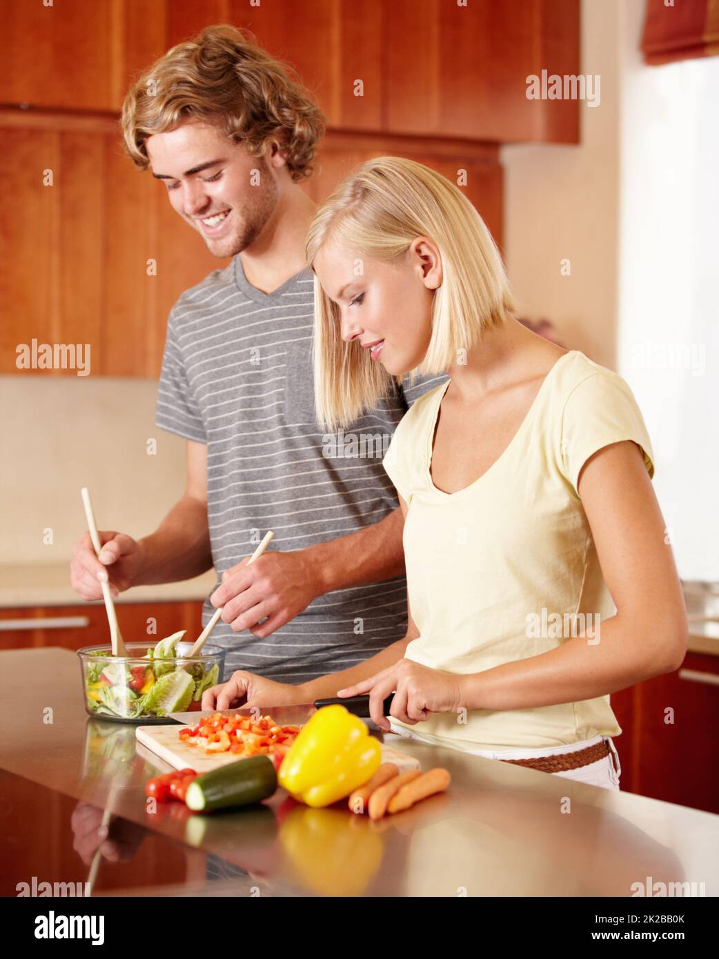 Salat machen. Ein junges Paar bereitet in der Küche etwas zu. Stockfoto
