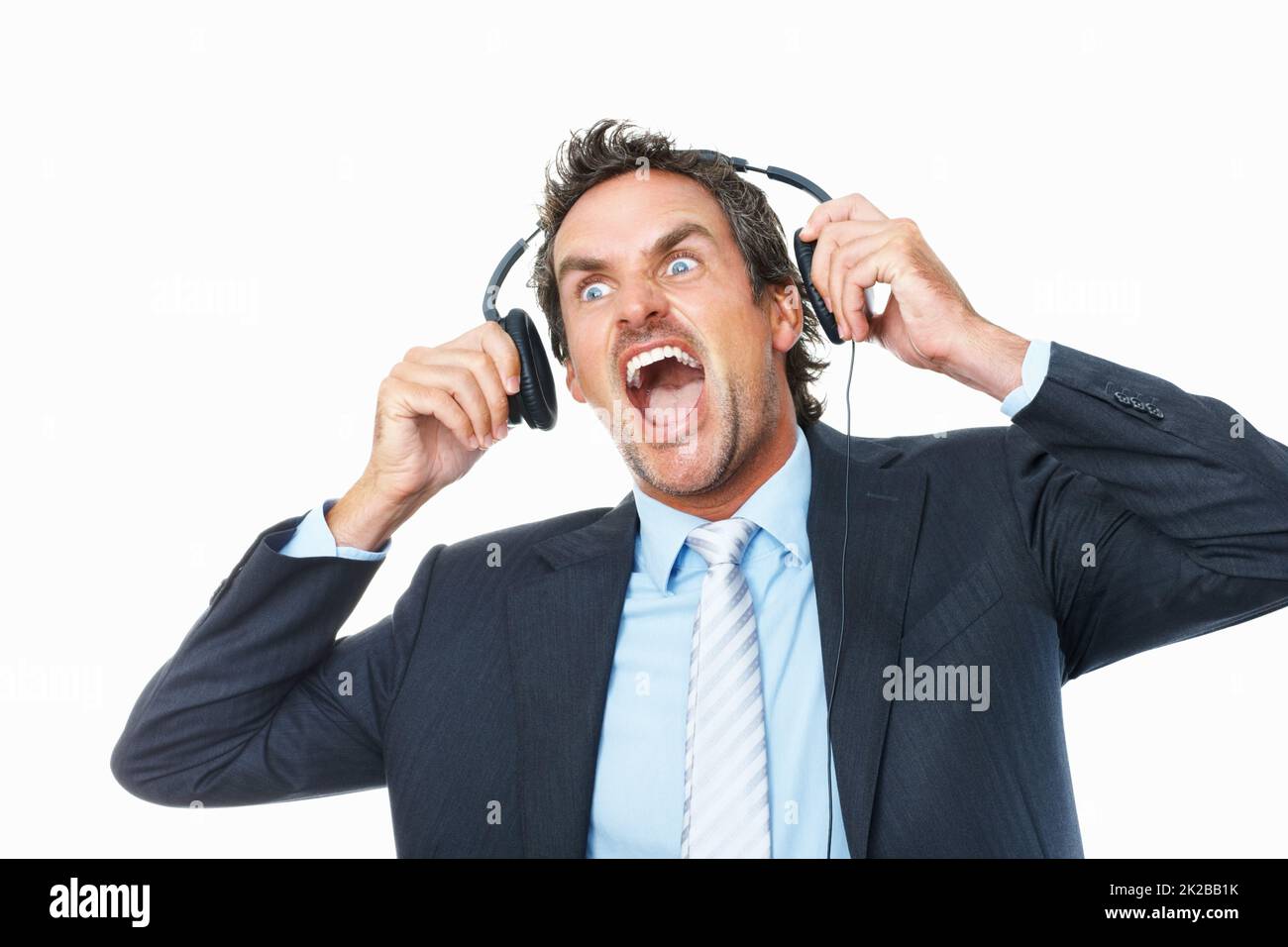 Geschäftsmann schockiert von lauter Musik auf Kopfhörern. Schockiert reifer Geschäftsmann Entfernen Kopfhörer vor weißem Hintergrund. Stockfoto