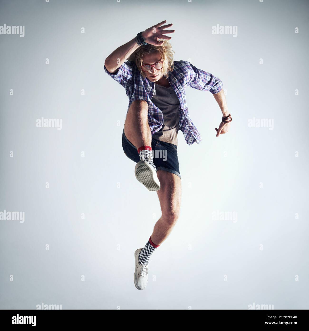 Er drückt sich durch Tanz aus. Aufnahme eines hübschen jungen Mannes, der vor grauem Hintergrund tanzt. Stockfoto