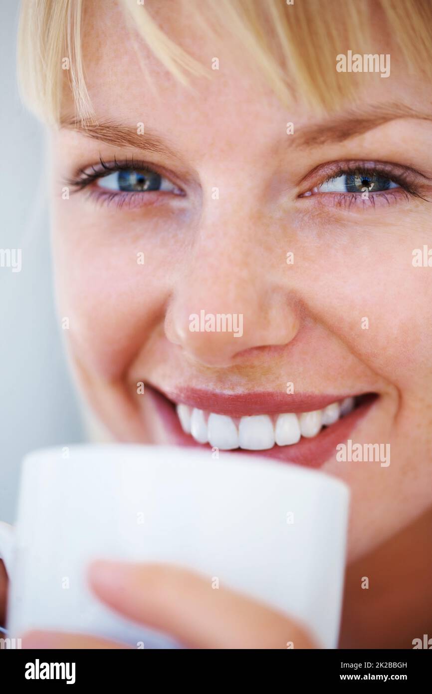 Hübsche junge Frau mit Kaffeetasse. Mikroansicht einer attraktiven jungen Frau, die Kaffee trinkt. Stockfoto