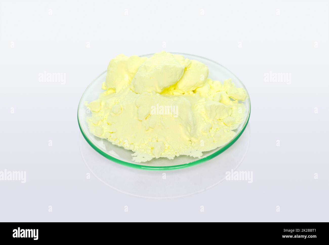 Schwefelpulver in chemischem Uhrenglas. Chemische Zutat aus der Nähe auf weißem Labortisch. Stockfoto