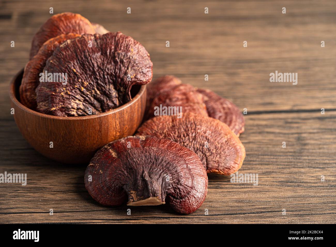 Getrocknete Lingzhi in Schüssel Pilz auf Holz Hintergrund. Stockfoto
