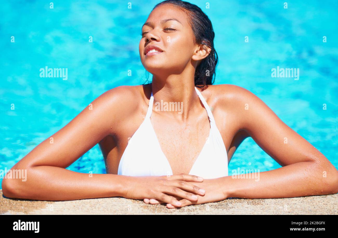 Sonne tanken. Kurzer Blick auf eine junge Frau in einem Schwimmbad, die die Sonne genießt. Stockfoto