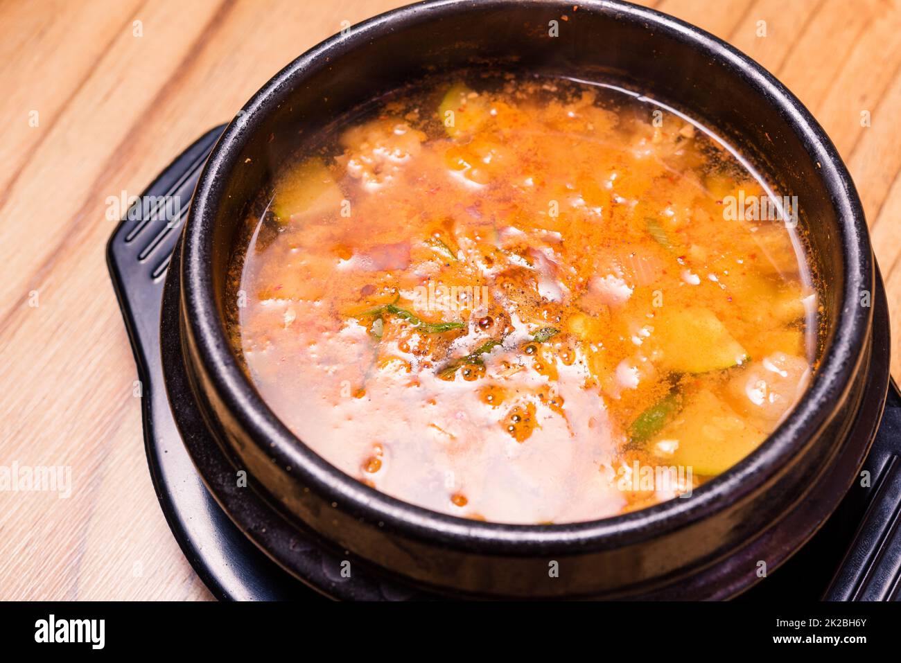 Kimchi-Suppe im heißen schwarzen Eisentopf, koreanische traditionelle ...
