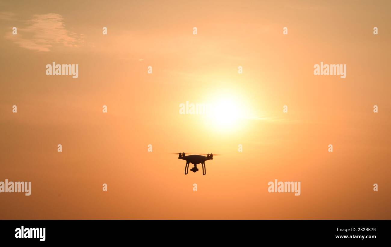 Die Silhouette der Drohne vor dem Hintergrund des Sonnenuntergangs Stockfoto