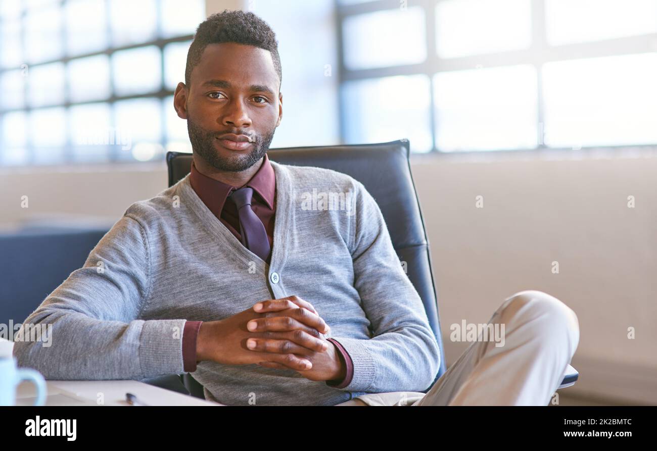 Hes machte es groß. Porträt eines jungen Geschäftsmannes, der in einem Büro an seinem Schreibtisch sitzt. Stockfoto