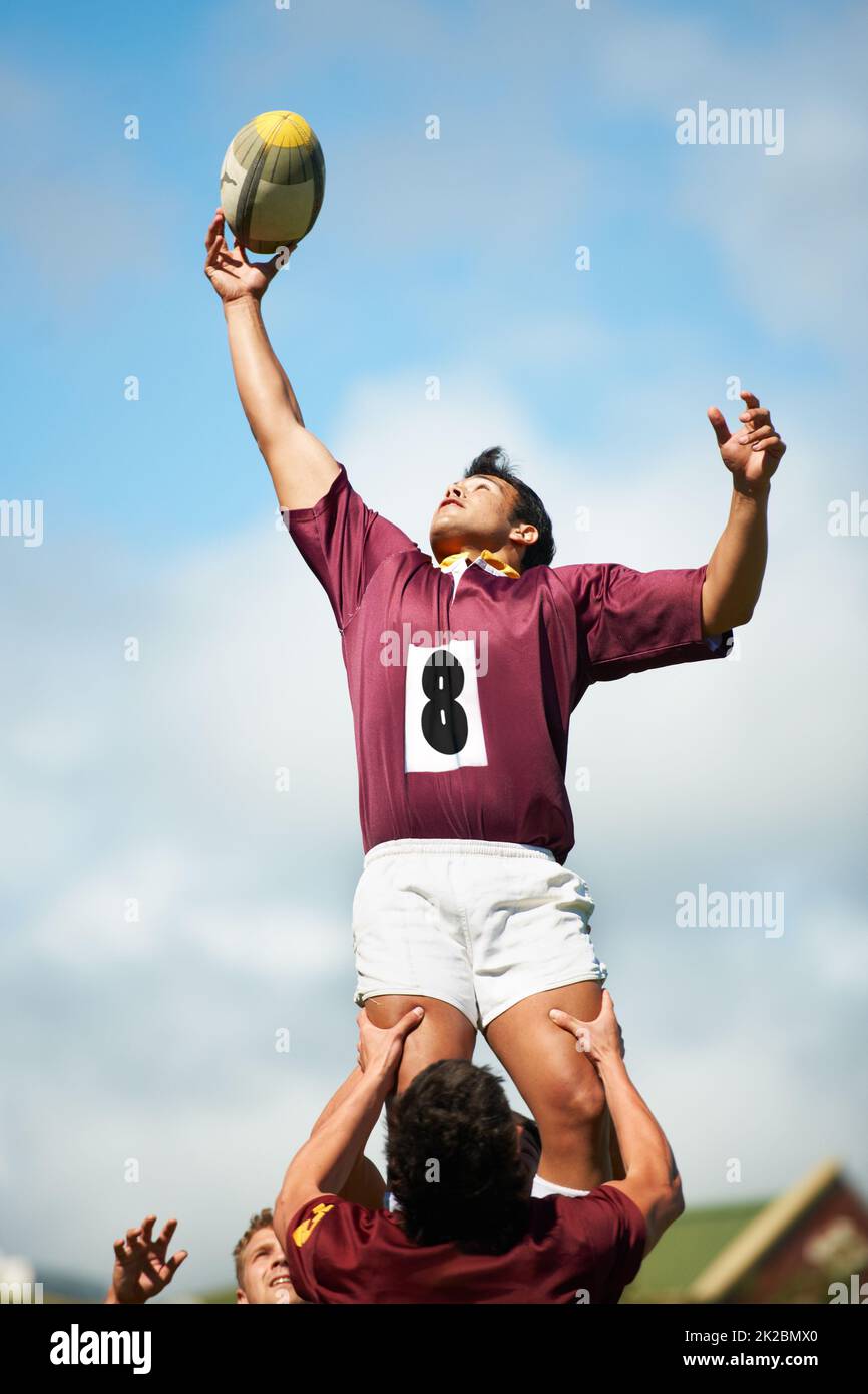 Die Freiheit zu tun, was du liebst. Aufnahme eines jungen Rugby-Spielers, der den Ball während eines Lineout fängt. Stockfoto