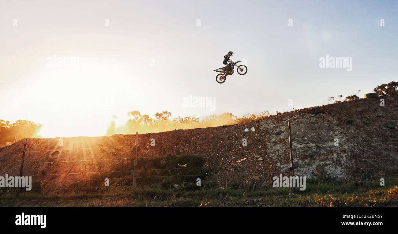 Es ist kein Wettbewerber in Sicht. Aufnahme eines Motocross-Fahrers, der während eines Rennens über einen Sprung fährt. Stockfoto