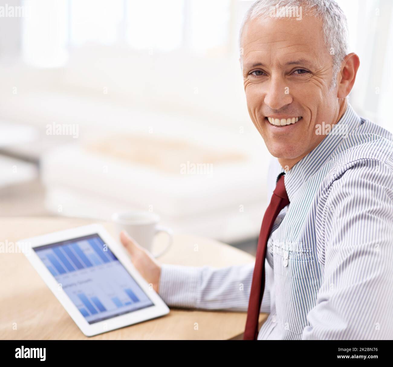 Ich mag, was ich sehe. Aufnahme eines Geschäftsmannes, der zufrieden über die Quartalsergebnisse auf seinem Tablet sieht. Stockfoto