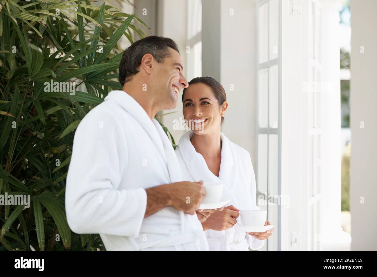 Freude und Entspannung im Day Spa. Aufnahme eines liebevollen, reifen Paares, das eine Tasse Kaffee in einem Day Spa genießt. Stockfoto