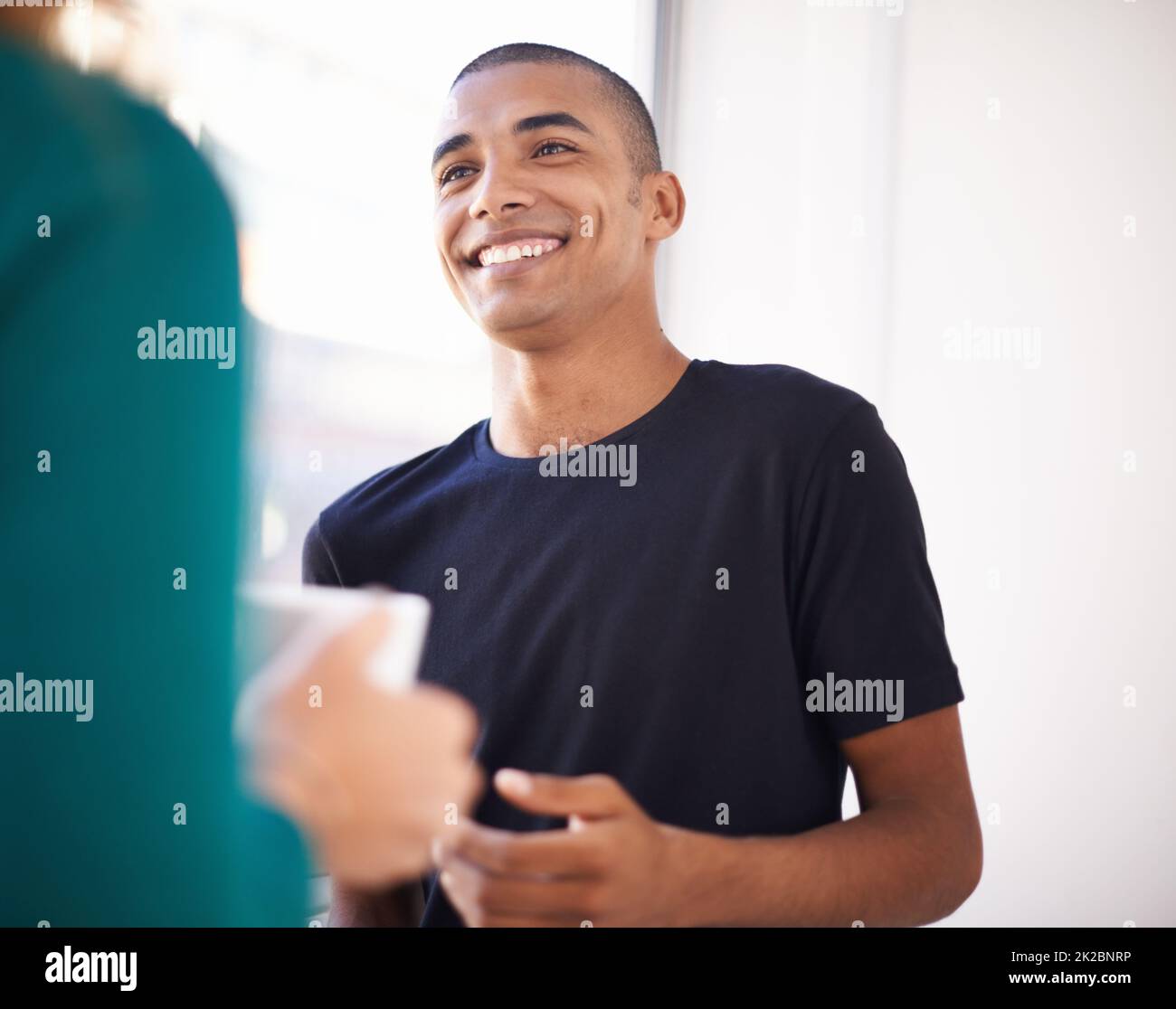 Plaudern bei einem Kaffee. Eine kurze Aufnahme von lässig gekleideten Kollegen, die sich bei der Arbeit unterhalten. Stockfoto