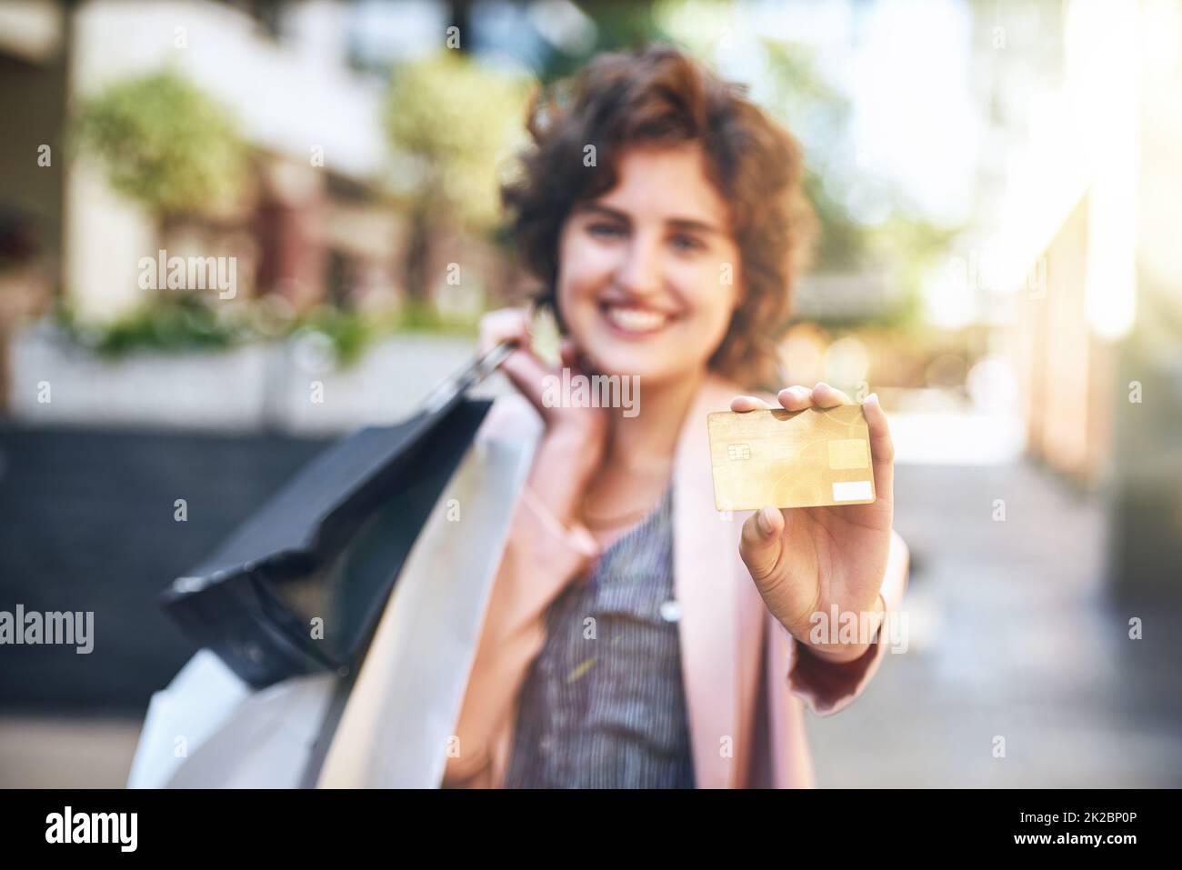 Dadurch sparen Sie Zeit und Ärger. Aufnahme einer Frau, die ihre Kreditkarte beim Einkaufen hochhält. Stockfoto