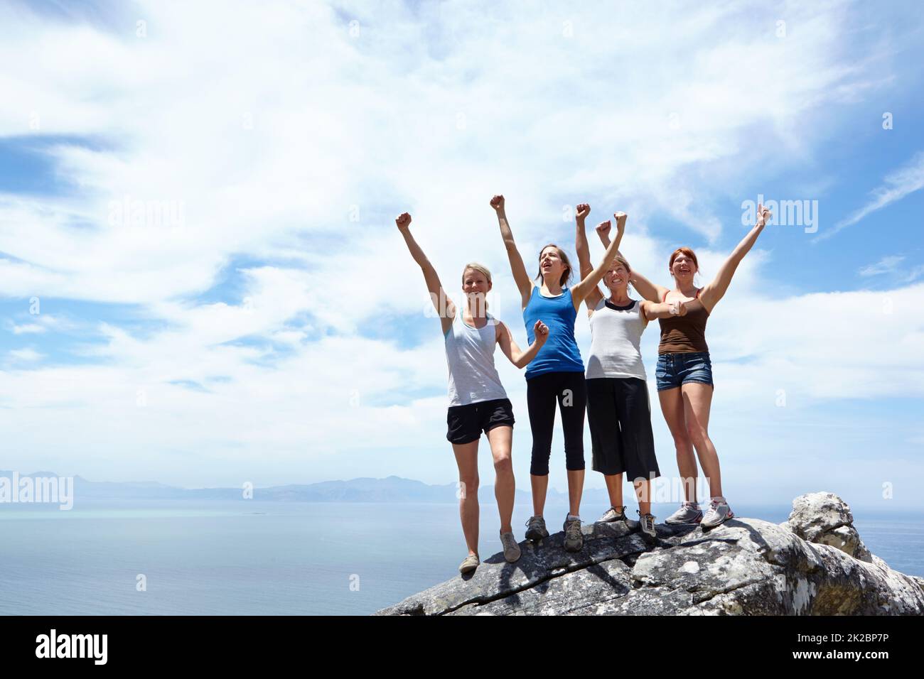 An die Spitze. Aufnahme einer Gruppe von Freunden, die sich freuen, nachdem sie den Gipfel eines Berges erreicht haben. Stockfoto