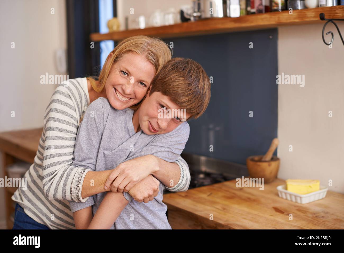 Zu schnell aufwachsen. Ein Porträt einer liebevollen Mutter und eines Sohnes, die zu Hause in ihrer Küche stehen. Stockfoto