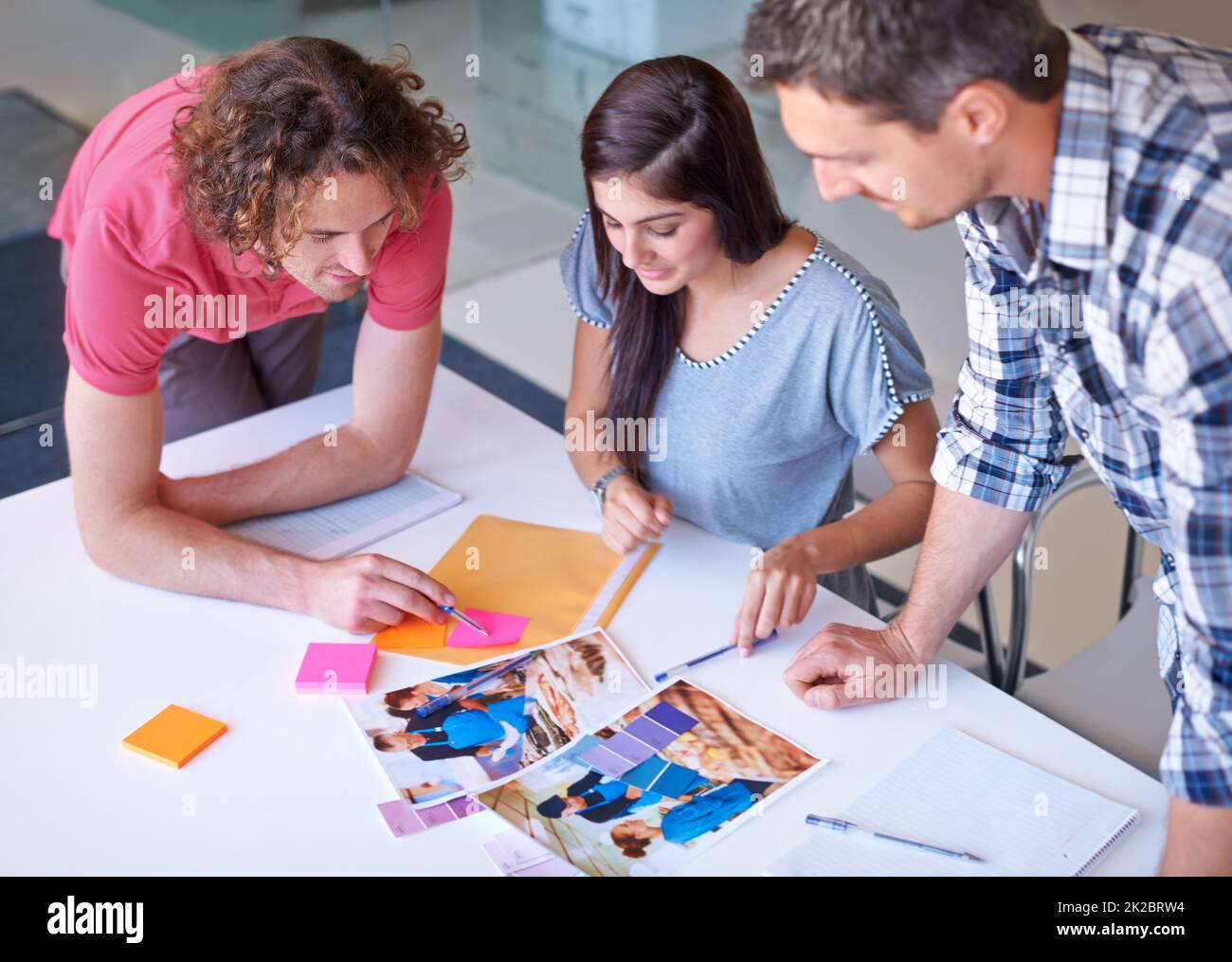 Das scheint die richtige Wahl zu sein. Drei Kollegen entscheiden sich für die richtige Farbgebung für ein Fotoshooting. Stockfoto