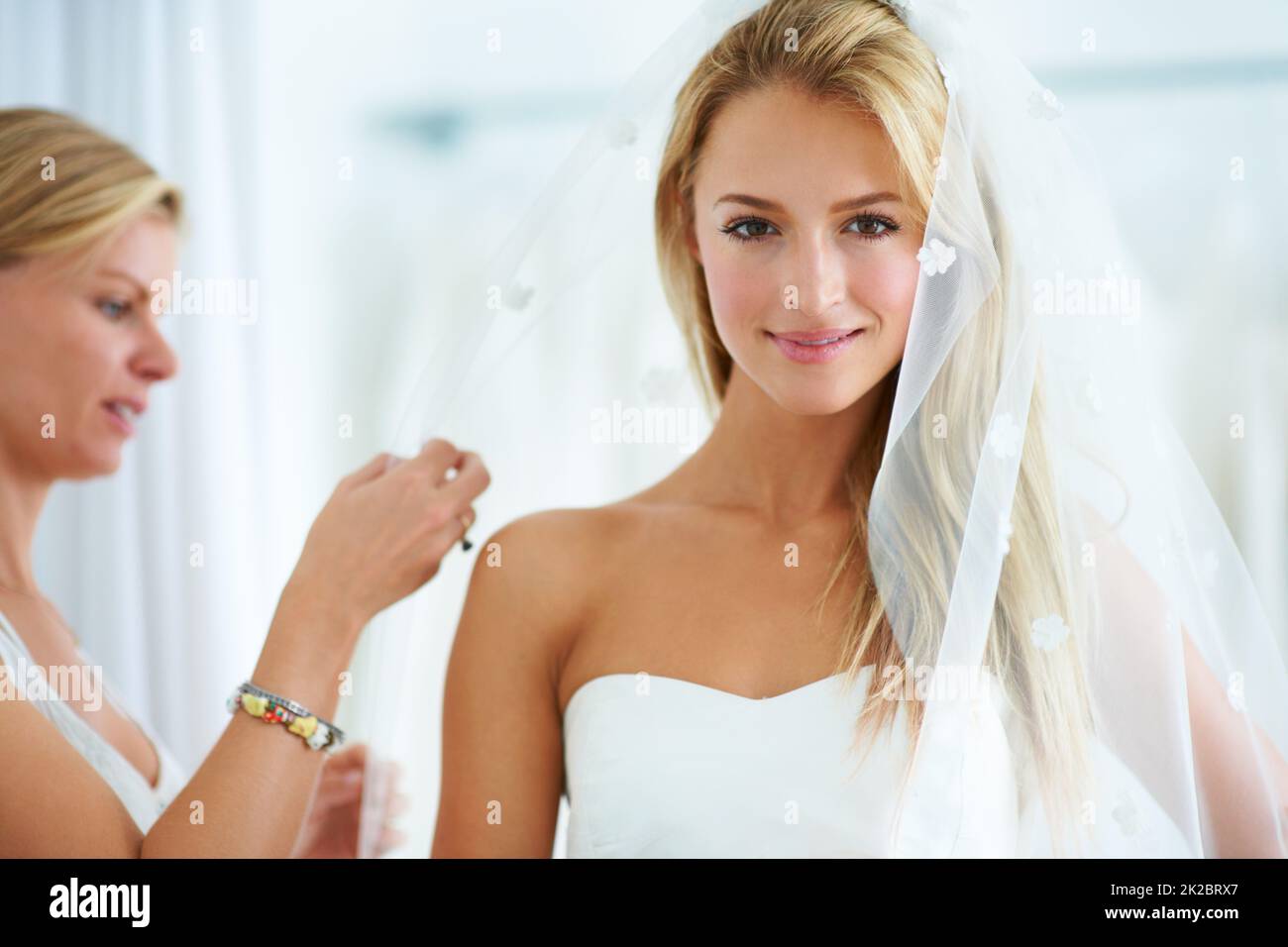 Den letzten Schliff geben. Eine junge Frau, die in einer Brautkleider-Boutique Brautkleider anprobiert. Stockfoto