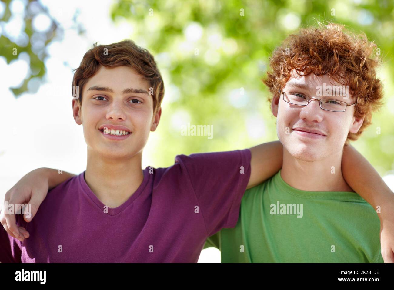 Zwei Erbsen im Park. Porträt von zwei Jungen im Teenageralter, die im Park hängen. Stockfoto