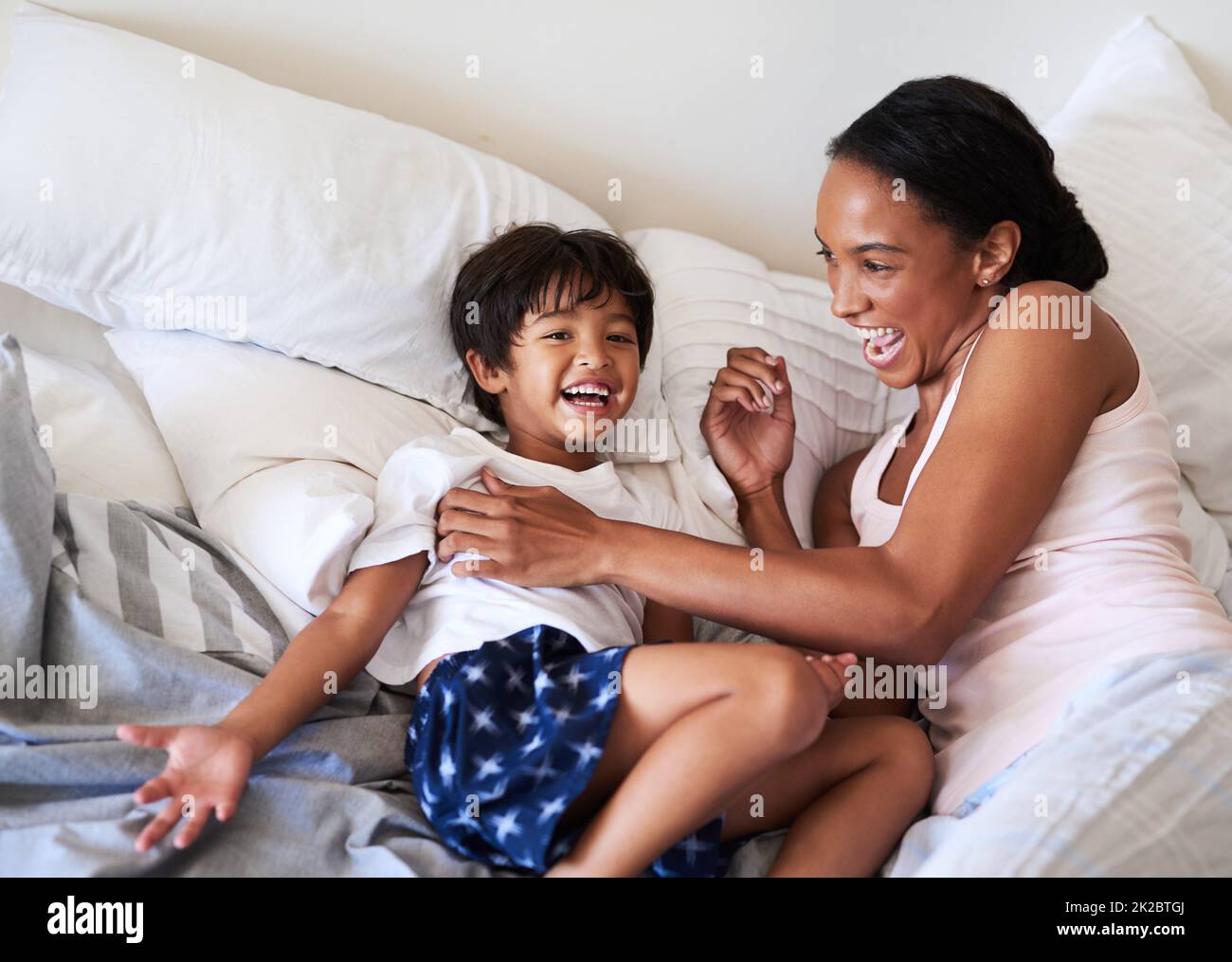 Meine kleine Bohne wächst so schnell auf. Aufnahme einer schönen jungen Mutter, die sich zu Hause im Bett mit ihrem Sohn entspannt. Stockfoto