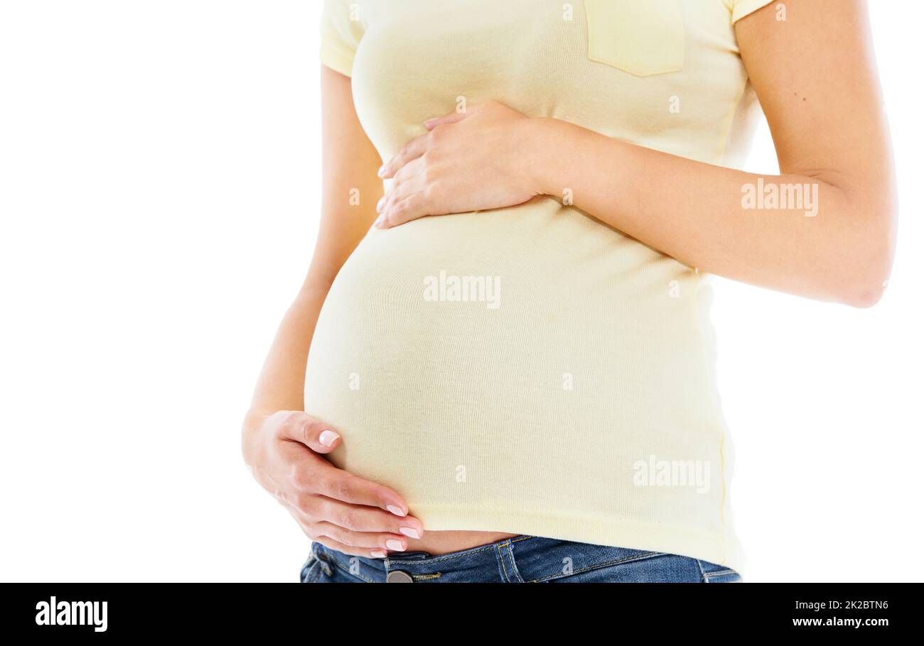 Ihr Kind lieben. Eine junge, schwanger gebliebene Frau, die ihren Bauch liebevoll hält. Stockfoto