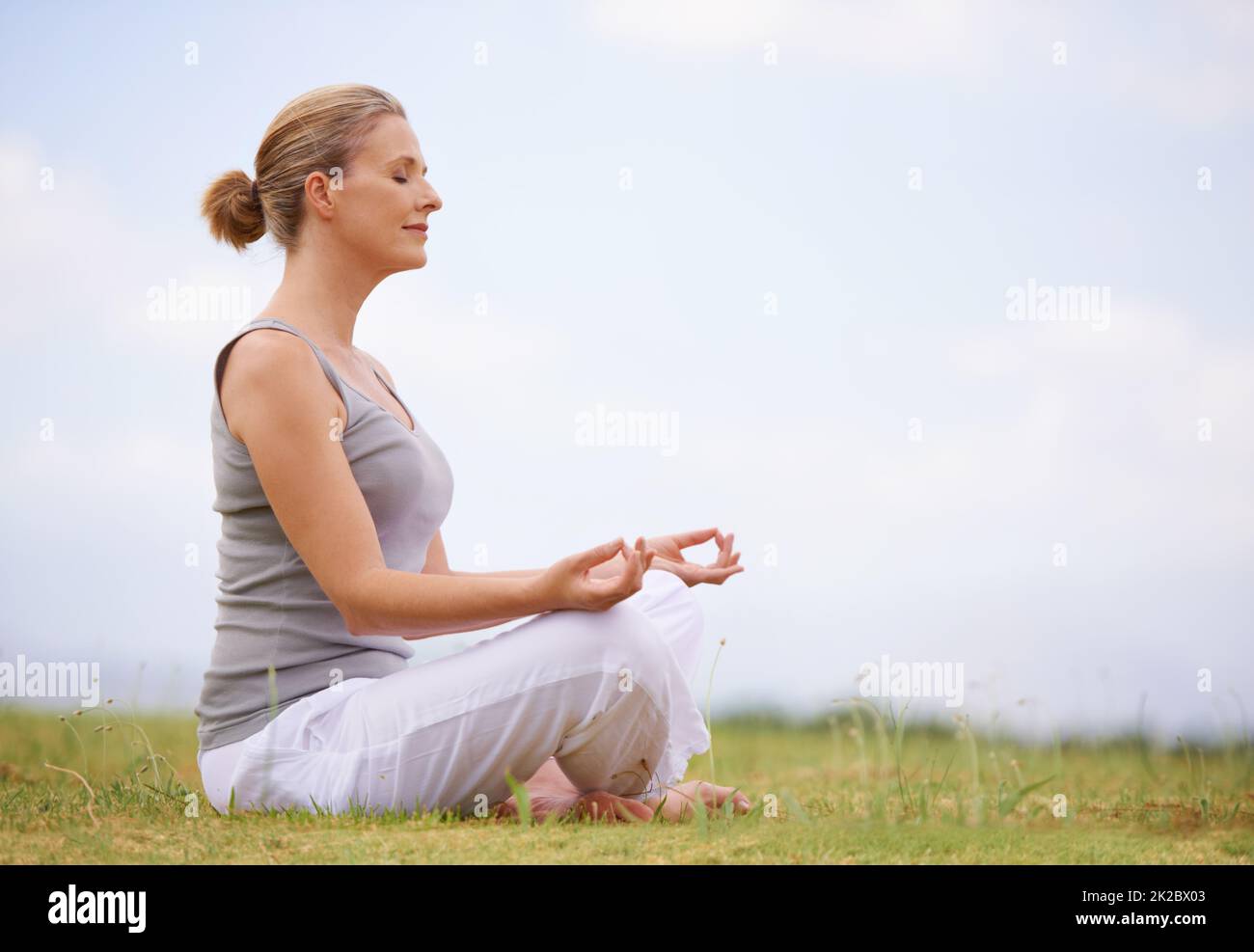 Sich in der Natur ruhig fühlen. Eine Frau, die Yoga macht. Stockfoto