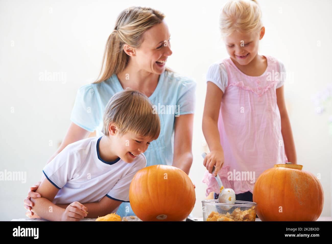 Kürbisse schnitzen mit Mama. Eine Mutter, ihr Sohn und ihre Tochter höhlen zu halloween Kürbisse aus. Stockfoto