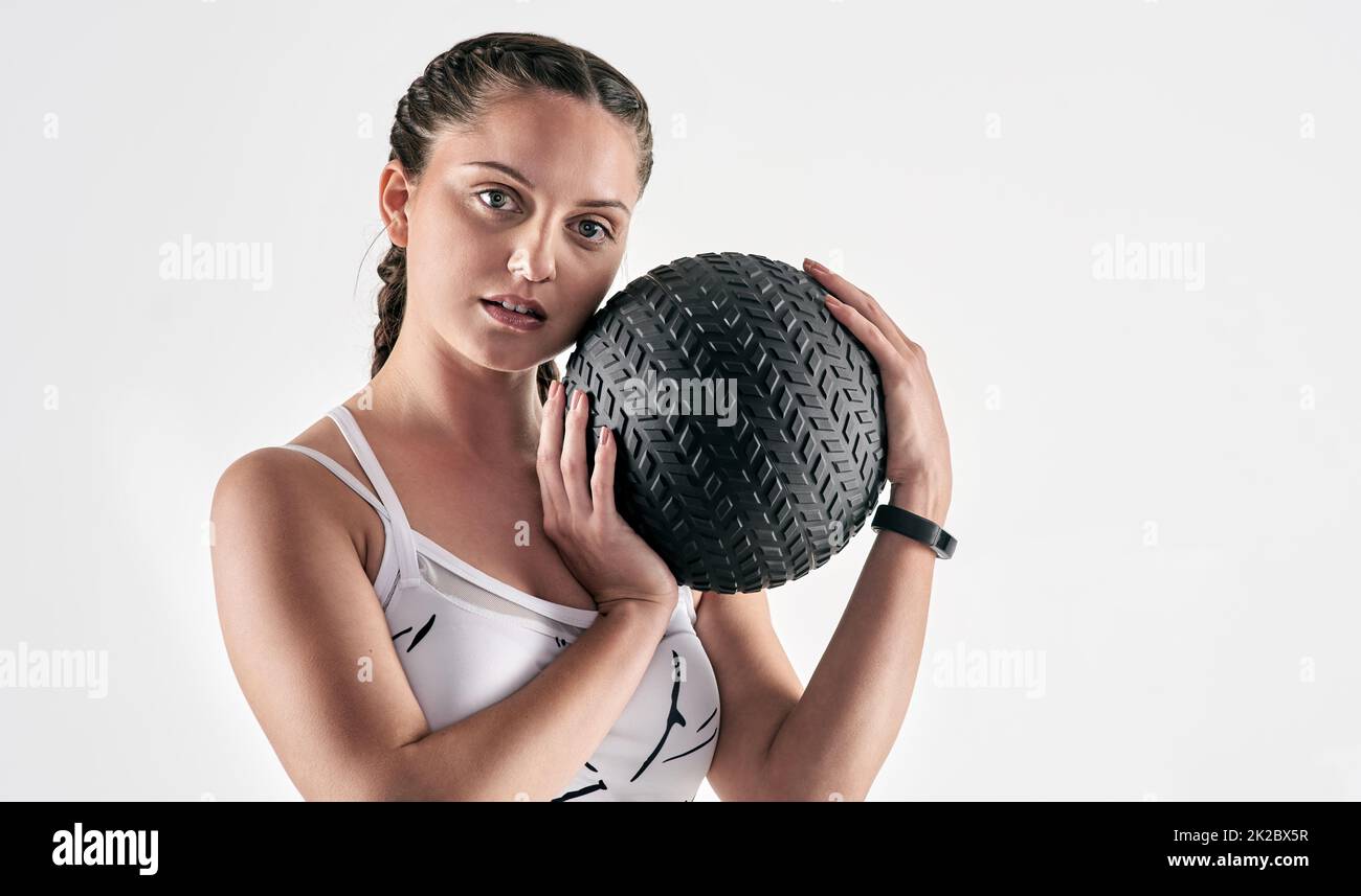 Machen Sie es passieren Mädchen. Schockieren Sie alle. Studioportrait einer sportlichen jungen Frau, die einen Übungsball vor weißem Hintergrund hält. Stockfoto