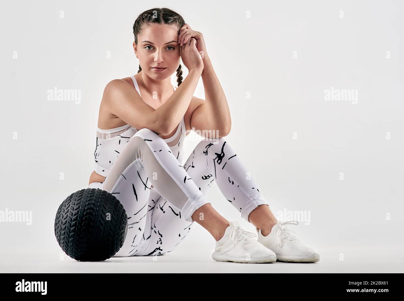 Ich verspreche mir, dass ich viel netter bin als mein ruhender Fitnessbereich. Studioportrait einer sportlichen jungen Frau, die mit einem Übungsball vor weißem Hintergrund posiert. Stockfoto
