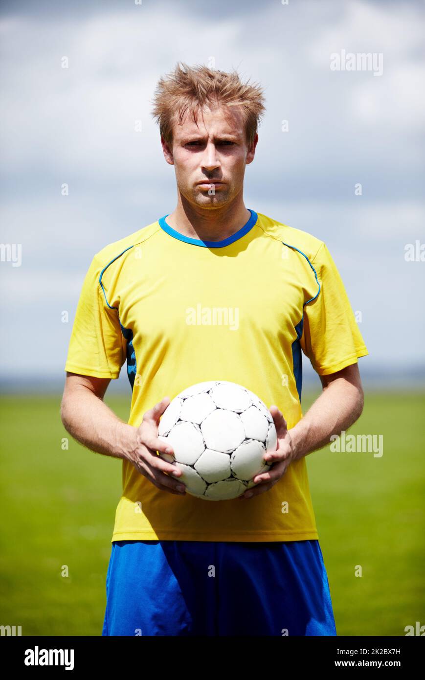 Ich werde mich nicht mit weniger als einem Sieg zufrieden geben. Aufnahme eines entschlossen aussehenden Fußballspielers, der einen Fußball im Freien hält. Stockfoto